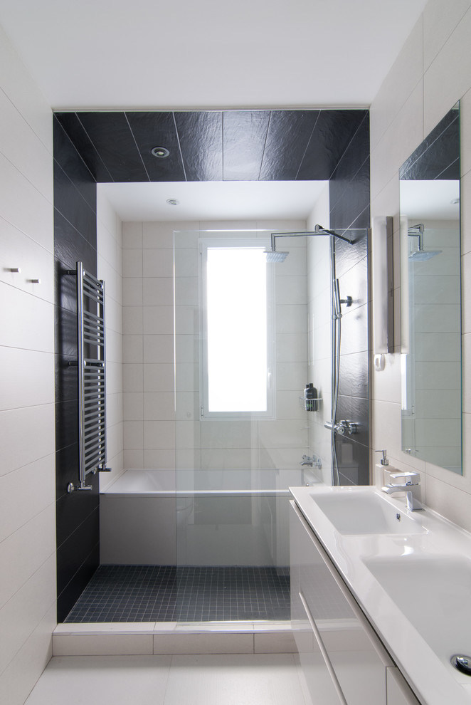 Imagen de cuarto de baño principal minimalista de tamaño medio con bañera empotrada, ducha abierta, paredes blancas, suelo de baldosas de cerámica y lavabo integrado