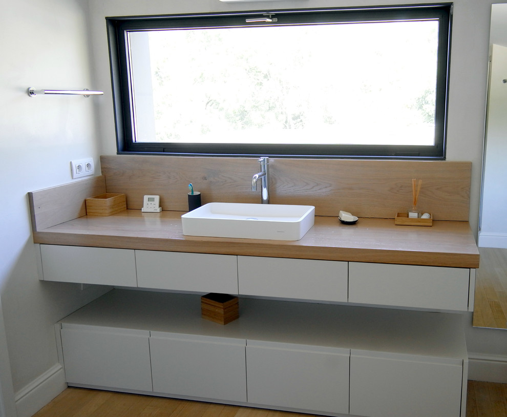 Ispirazione per una grande stanza da bagno moderna con pareti bianche, parquet chiaro e lavabo a bacinella