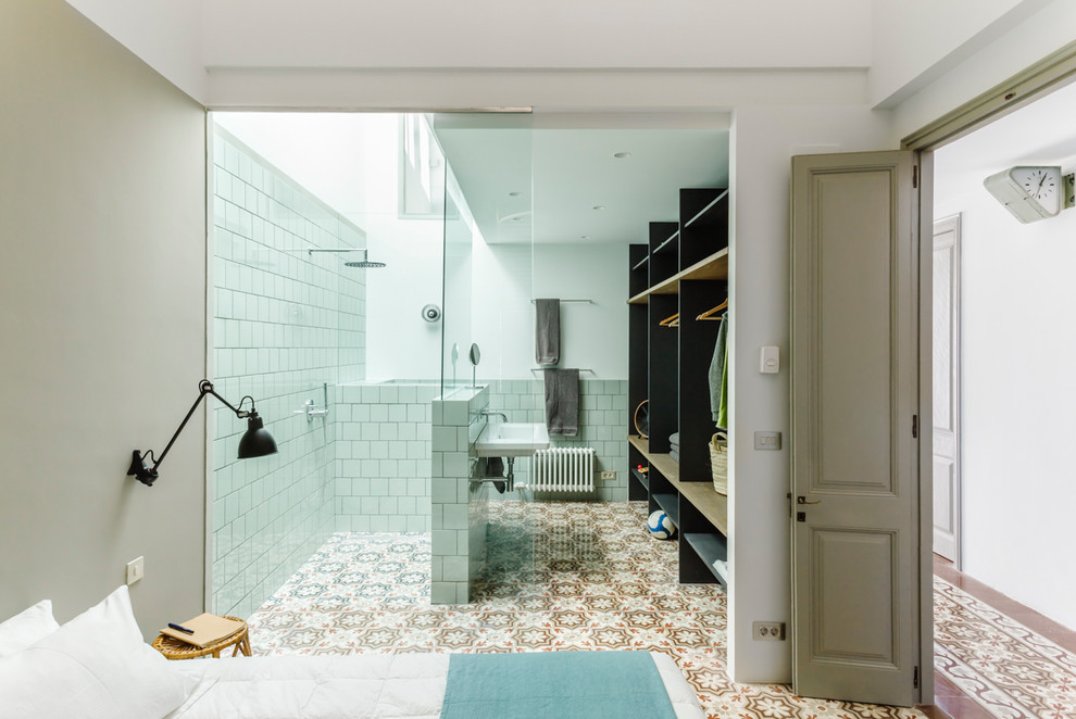 Idee per una stanza da bagno con doccia mediterranea con doccia a filo pavimento, piastrelle bianche, pareti bianche, lavabo sospeso, pavimento multicolore e porta doccia scorrevole
