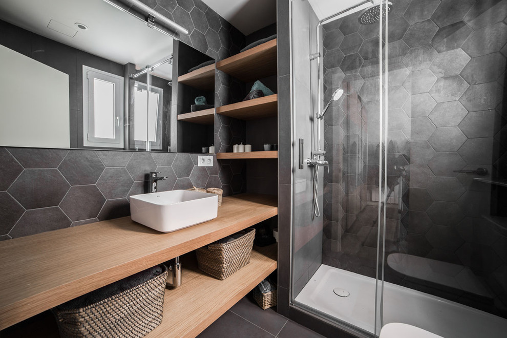 Idéer för att renovera ett funkis badrum med dusch, med öppna hyllor, skåp i ljust trä, en dusch i en alkov, svart kakel, grå kakel, skiffergolv, ett fristående handfat, träbänkskiva, svart golv och dusch med skjutdörr