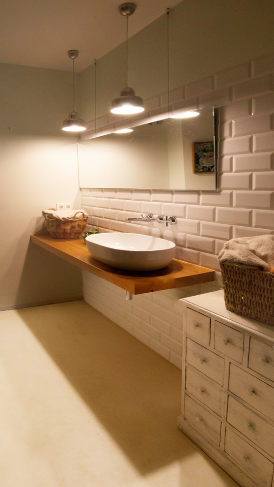 Foto de cuarto de baño principal minimalista de tamaño medio con paredes blancas, suelo de cemento, lavabo sobreencimera, encimera de madera, suelo beige, baldosas y/o azulejos blancos y baldosas y/o azulejos de cemento