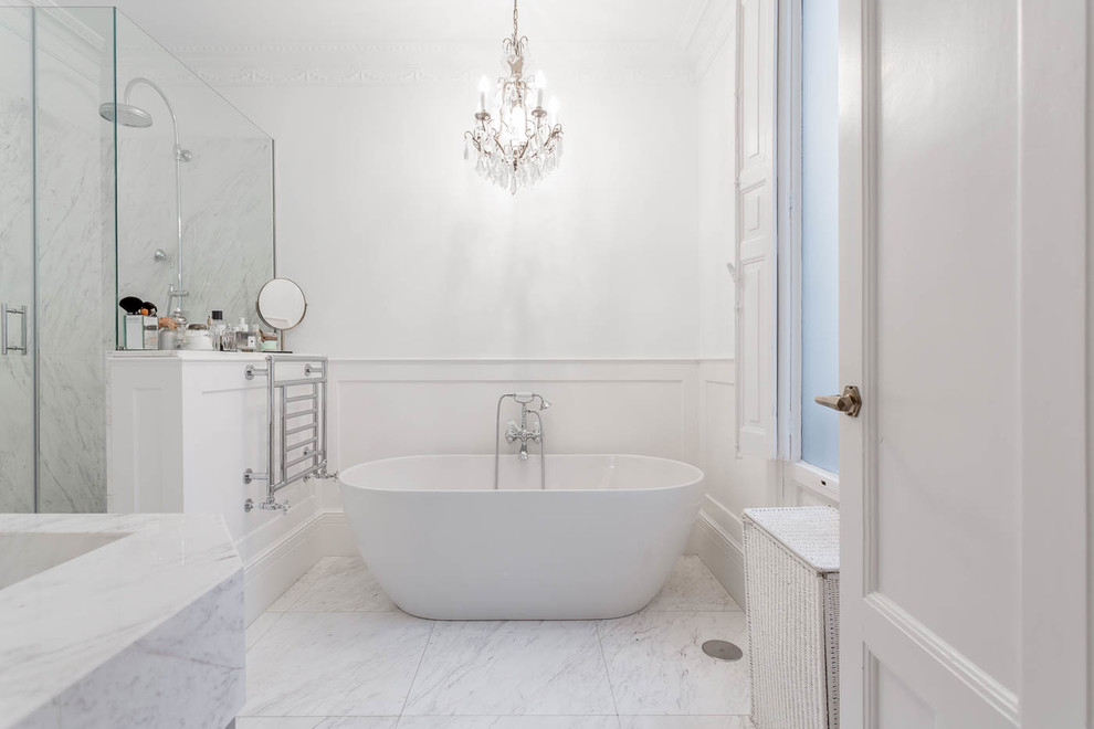 Imagen de cuarto de baño principal tradicional de tamaño medio con bañera exenta, combinación de ducha y bañera, paredes blancas, suelo de mármol, suelo blanco y ducha abierta