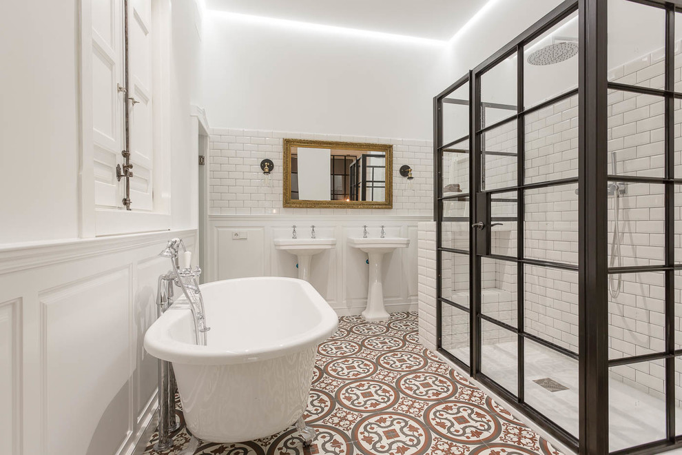 Идея дизайна: большая главная ванная комната в средиземноморском стиле с ванной на ножках, душем в нише, белой плиткой, плиткой кабанчик, белыми стенами, полом из керамической плитки, раковиной с пьедесталом, разноцветным полом и душем с распашными дверями