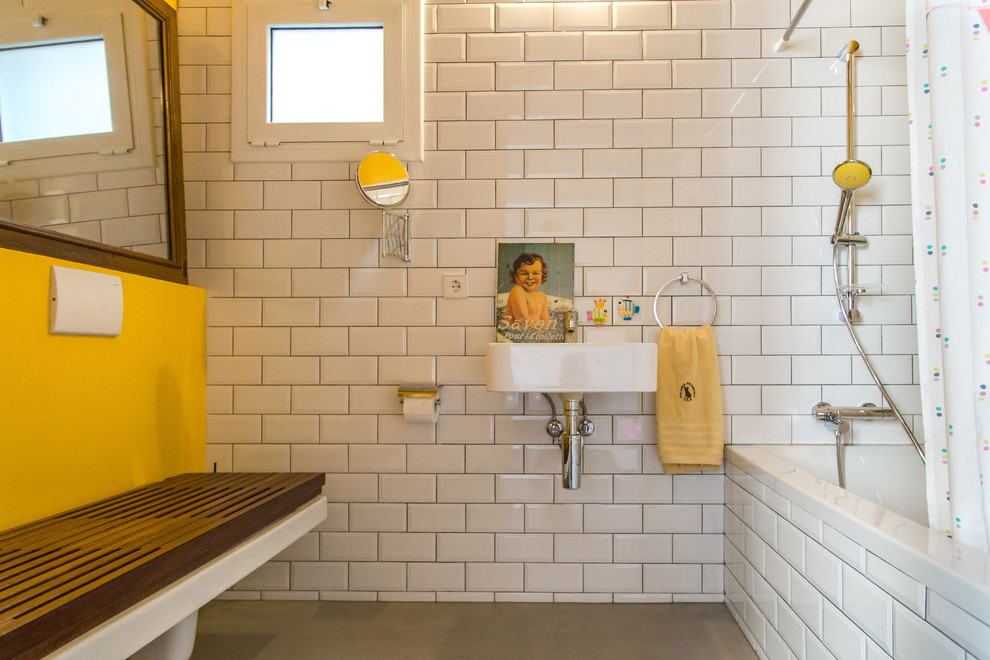 Inspiration pour une salle de bain bohème de taille moyenne pour enfant avec une baignoire en alcôve, un combiné douche/baignoire, WC à poser, un mur jaune et un lavabo suspendu.