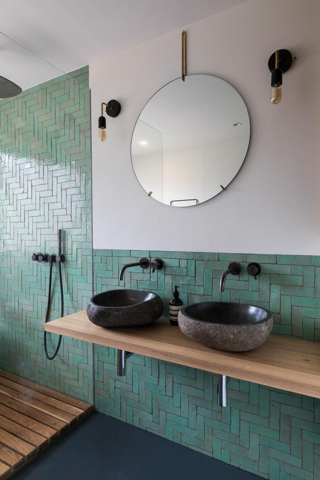 Bild på ett minimalistiskt brun brunt badrum, med öppna hyllor, en hörndusch, grön kakel, keramikplattor, beige väggar, ett fristående handfat, träbänkskiva, svart golv och med dusch som är öppen