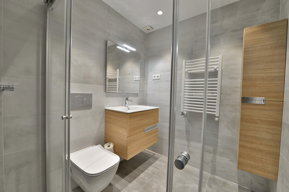 Photo of a medium sized contemporary bathroom in Madrid with flat-panel cabinets, white cabinets, a built-in shower, ceramic tiles, grey walls, porcelain flooring, grey floors, an enclosed toilet and a single sink.