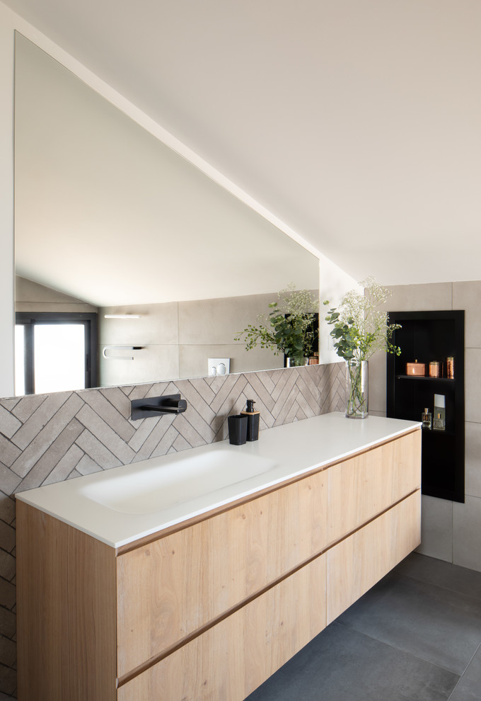 На фото: ванная комната в современном стиле с плоскими фасадами, светлыми деревянными фасадами, бежевой плиткой, белыми стенами, монолитной раковиной, серым полом и белой столешницей