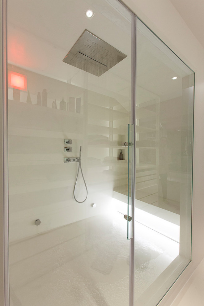Cette image montre un sauna design de taille moyenne avec un mur blanc, sol en béton ciré et un sol blanc.