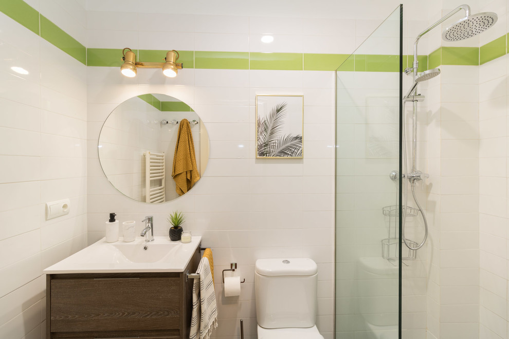Imagen de cuarto de baño tropical con ducha esquinera, sanitario de una pieza, baldosas y/o azulejos verdes, baldosas y/o azulejos blancos, paredes blancas, lavabo tipo consola y ducha abierta