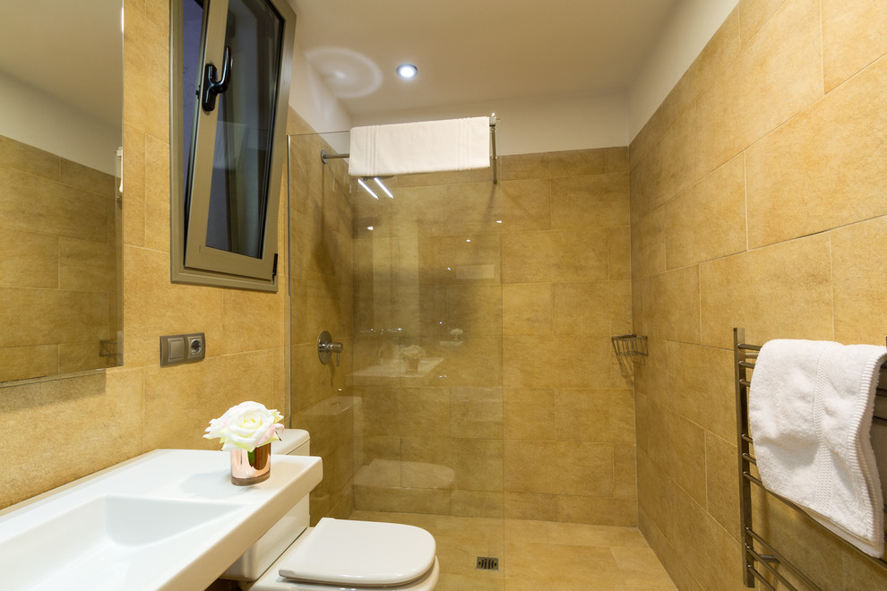 Idéer för små medelhavsstil en-suite badrum, med öppna hyllor, ett badkar i en alkov, en kantlös dusch, en toalettstol med hel cisternkåpa, beige kakel, keramikplattor, beige väggar, klinkergolv i keramik, ett väggmonterat handfat, marmorbänkskiva, beiget golv och med dusch som är öppen