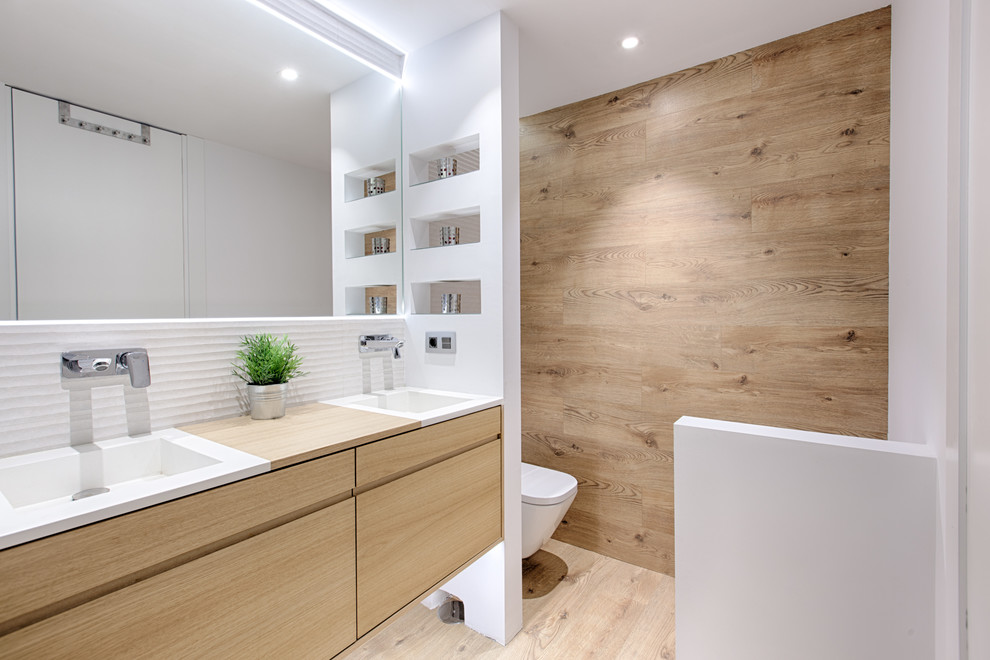 Foto di una piccola stanza da bagno con doccia moderna con ante lisce, ante in legno chiaro, pareti bianche, lavabo integrato e top in legno