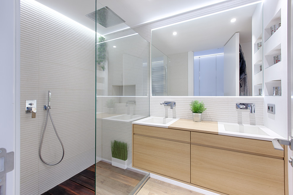 Skandinavisk inredning av ett litet beige beige badrum med dusch, med släta luckor, skåp i ljust trä, en dusch i en alkov, vita väggar, ett integrerad handfat, träbänkskiva, ljust trägolv, beiget golv och med dusch som är öppen