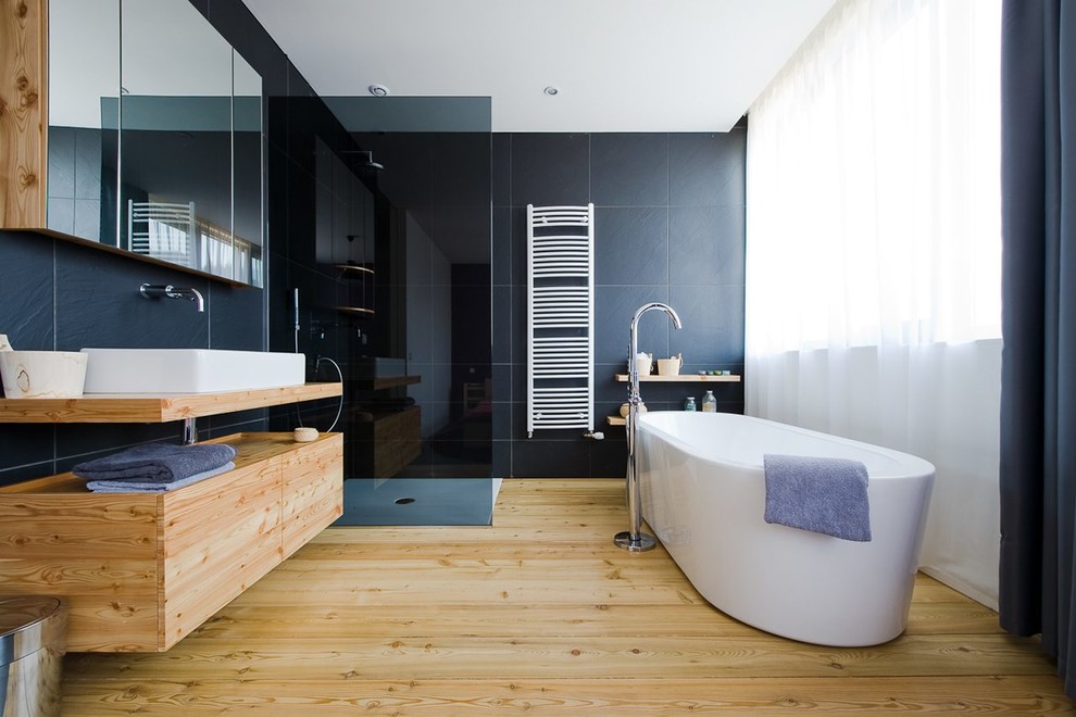 Foto de cuarto de baño principal clásico renovado de tamaño medio con bañera exenta, encimera de madera, puertas de armario de madera clara, encimeras marrones y armarios con paneles lisos
