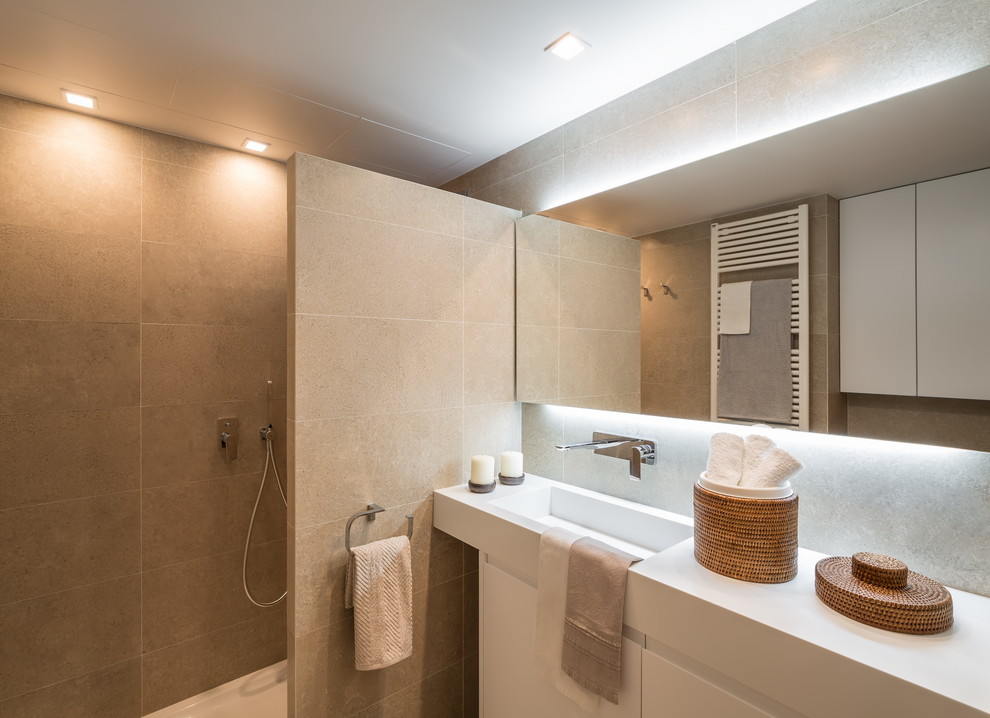 Esempio di una stanza da bagno minimal di medie dimensioni con ante lisce, ante bianche, pareti beige e lavabo integrato
