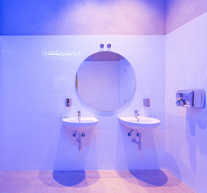 Modelo de cuarto de baño doble contemporáneo con puertas de armario blancas, baldosas y/o azulejos blancos, baldosas y/o azulejos de cerámica, paredes blancas, suelo de cemento, lavabo suspendido y suelo gris