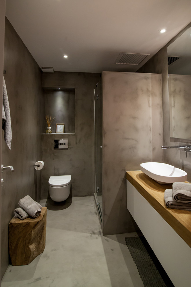 Mittelgroßes Modernes Duschbad mit Eckdusche, Wandtoilette, grauer Wandfarbe, Aufsatzwaschbecken, Waschtisch aus Holz, flächenbündigen Schrankfronten und weißen Schränken in Barcelona