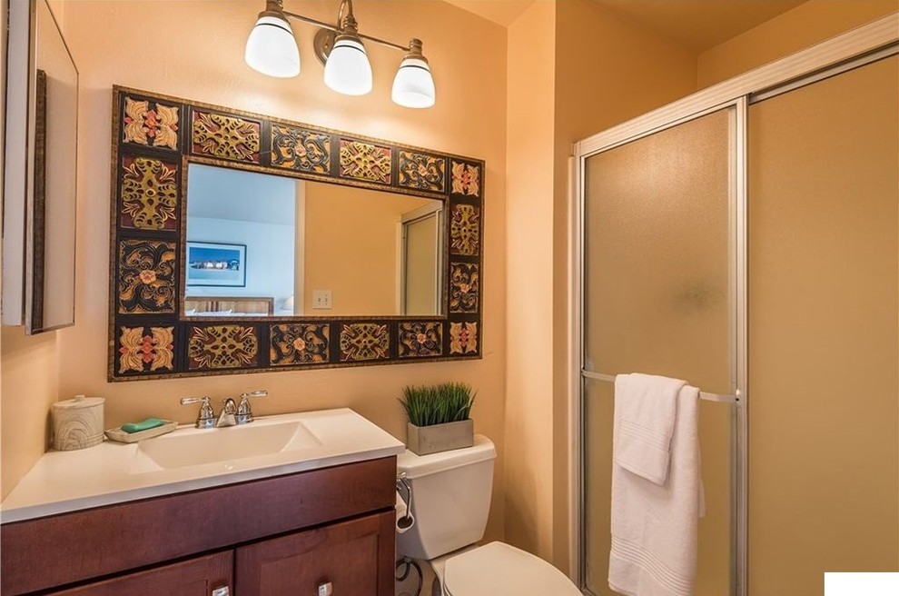 Bathroom - small contemporary master beige tile and ceramic tile ceramic tile and beige floor bathroom idea in Los Angeles with furniture-like cabinets, brown cabinets, a two-piece toilet, beige walls, a trough sink, solid surface countertops and white countertops