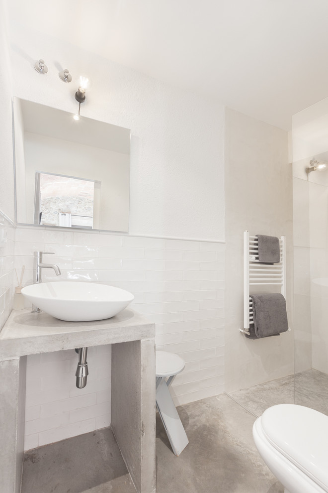 Идея дизайна: ванная комната среднего размера в средиземноморском стиле с открытыми фасадами, открытым душем, раздельным унитазом, белыми стенами, бетонным полом, душевой кабиной, настольной раковиной и столешницей из бетона