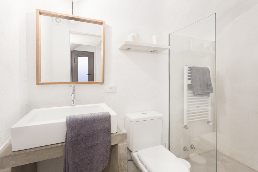 Стильный дизайн: ванная комната среднего размера в средиземноморском стиле с душем без бортиков, раздельным унитазом, белыми стенами, душевой кабиной, настольной раковиной и столешницей из бетона - последний тренд