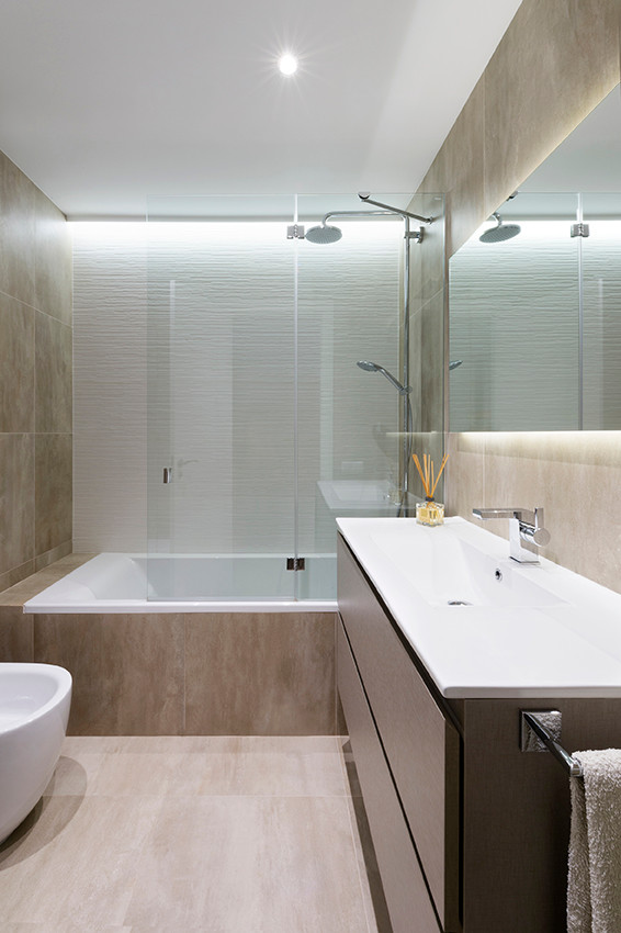 Modelo de cuarto de baño principal moderno de tamaño medio con armarios con paneles lisos, puertas de armario de madera en tonos medios, combinación de ducha y bañera y lavabo integrado