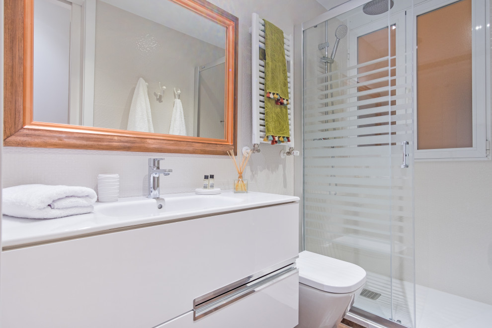 Inspiration pour une douche en alcôve design avec un placard à porte plane, des portes de placard blanches, un lavabo intégré, une cabine de douche à porte coulissante, meuble simple vasque et meuble-lavabo suspendu.