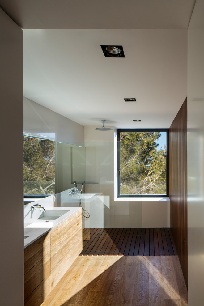 Idée de décoration pour une salle de bain design avec un mur gris, un sol en bois brun, un sol marron et un plan de toilette beige.