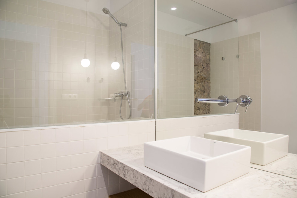 Diseño de cuarto de baño contemporáneo de tamaño medio con ducha a ras de suelo, paredes blancas, aseo y ducha, lavabo sobreencimera y encimera de granito