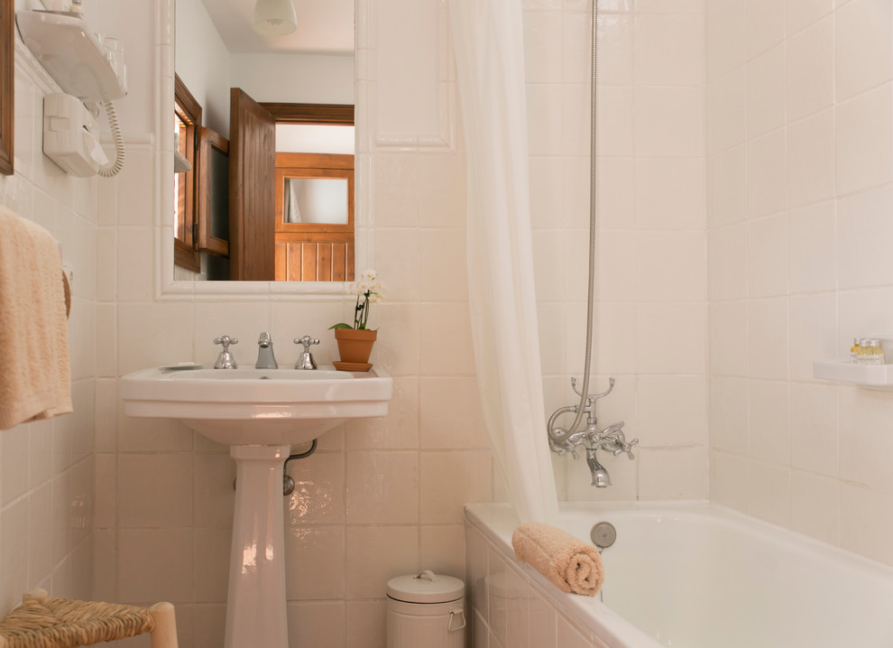 Modelo de cuarto de baño principal campestre pequeño con lavabo con pedestal, bañera empotrada, combinación de ducha y bañera, baldosas y/o azulejos blancos, baldosas y/o azulejos de porcelana, paredes blancas y ducha con cortina