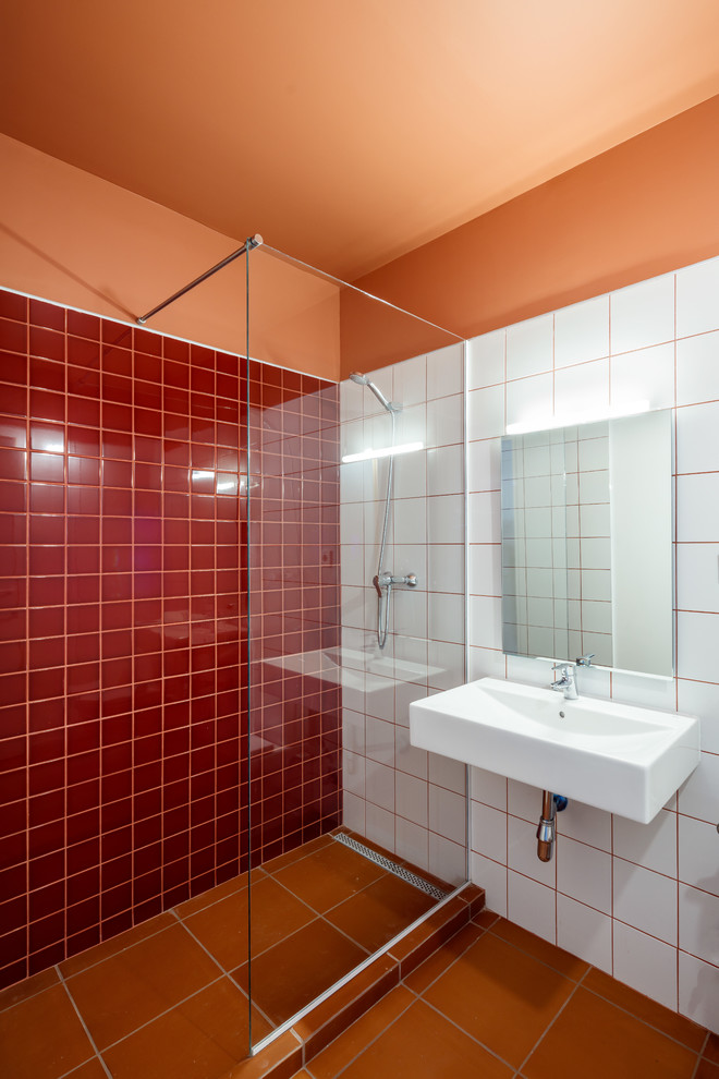 Ejemplo de cuarto de baño mediterráneo con baldosas y/o azulejos blancos, baldosas y/o azulejos rojos, aseo y ducha, encimeras blancas, ducha esquinera, parades naranjas, lavabo suspendido, suelo naranja y ducha abierta