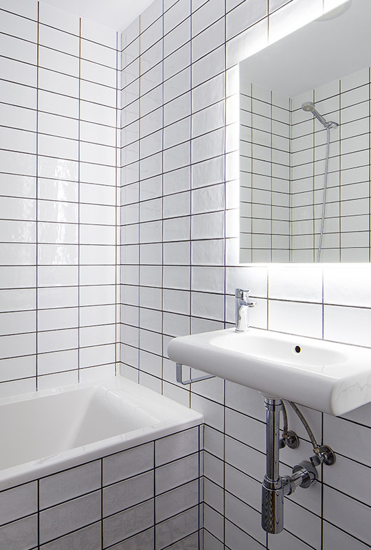 Immagine di una stanza da bagno padronale moderna di medie dimensioni con vasca da incasso, WC monopezzo, piastrelle bianche, piastrelle in ceramica, pareti bianche, pavimento con piastrelle in ceramica, lavabo a bacinella e pavimento bianco