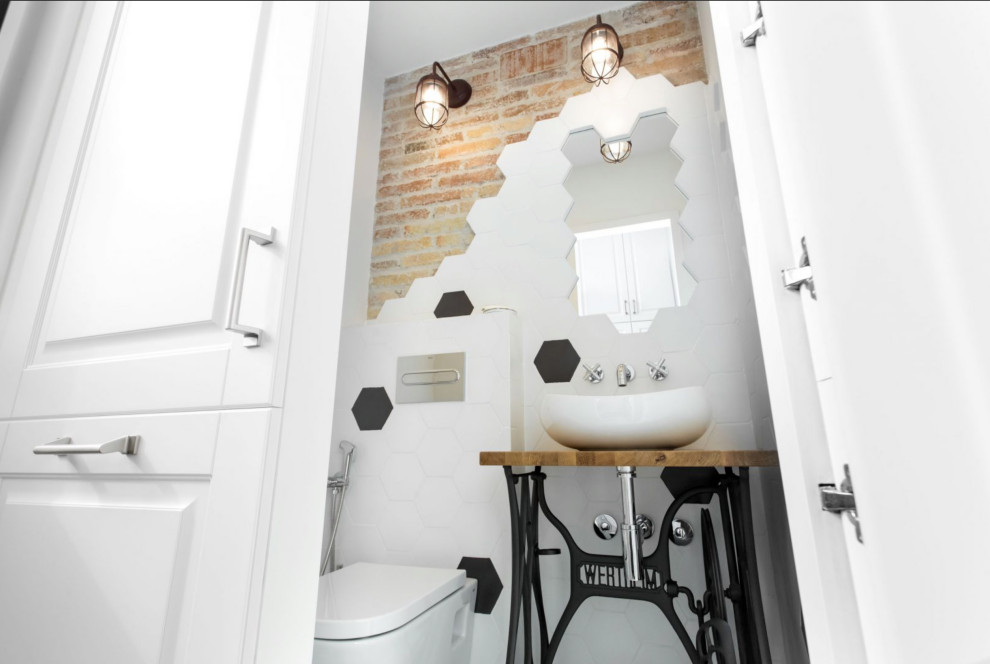 Idee per una piccola stanza da bagno industriale con ante in stile shaker, ante bianche, WC sospeso, pistrelle in bianco e nero, lavabo a consolle, top in legno, un lavabo, mobile bagno incassato e pareti in mattoni