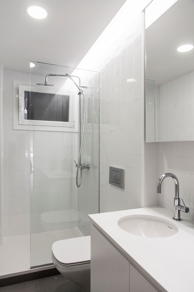 Esempio di una stanza da bagno con doccia nordica di medie dimensioni con ante lisce, ante bianche, doccia alcova, WC sospeso, pareti bianche e lavabo sottopiano
