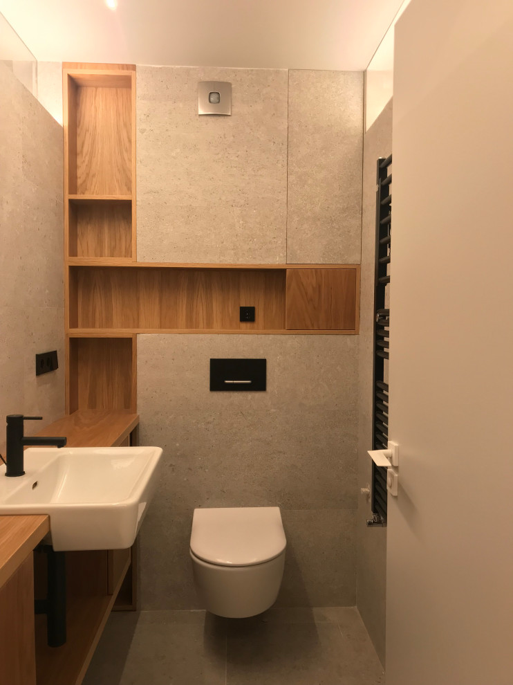 Immagine di una stanza da bagno minimal con consolle stile comò, ante bianche, piastrelle grigie, pareti grigie, pavimento con piastrelle in ceramica, top in legno e pavimento grigio