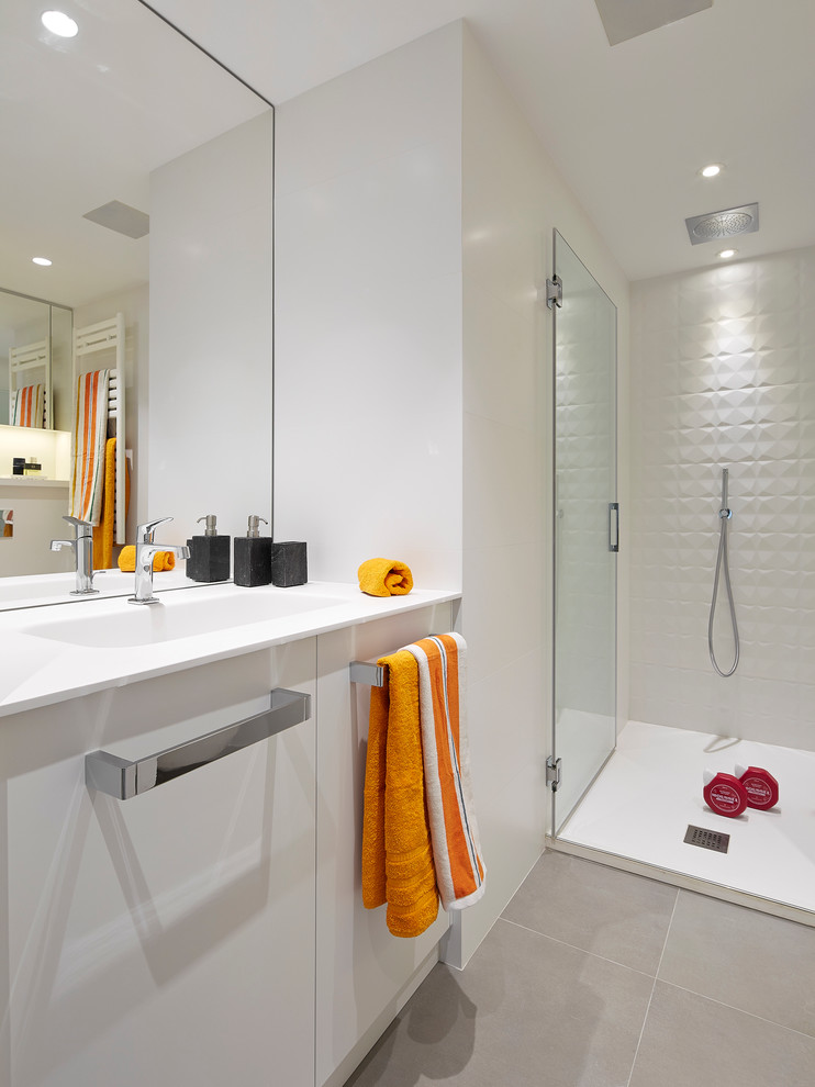 Diseño de cuarto de baño contemporáneo de tamaño medio con armarios con paneles lisos, puertas de armario blancas, ducha abierta, paredes blancas, suelo de baldosas de cerámica, aseo y ducha y lavabo integrado