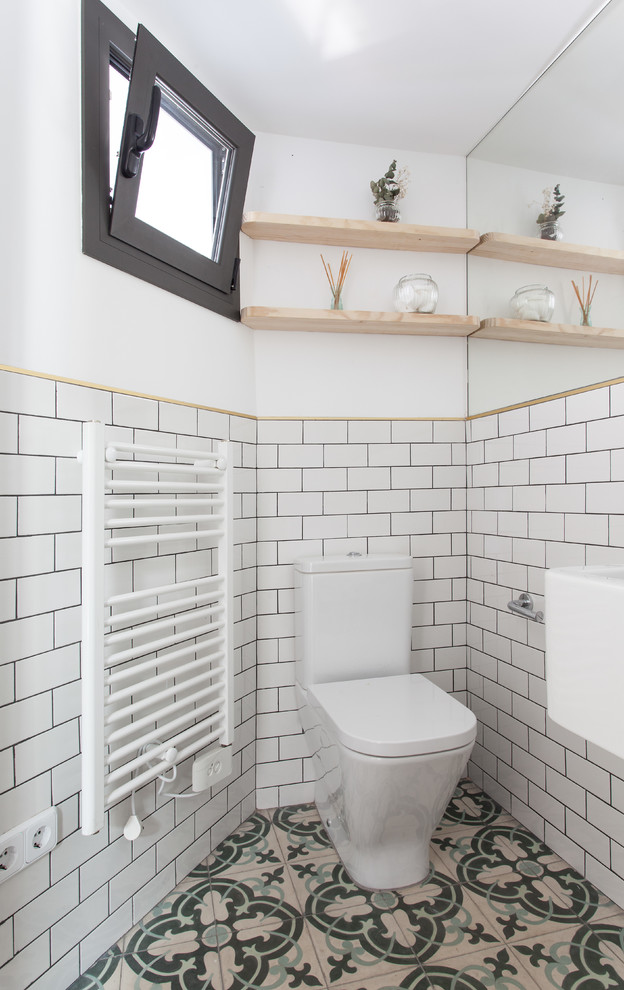 Small contemporary ensuite bathroom in Barcelona with open cabinets, a built-in shower, a one-piece toilet, white walls, terrazzo flooring and a wall-mounted sink.