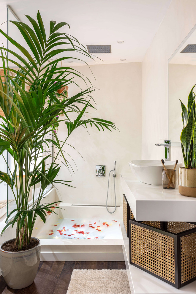 バルセロナにあるトロピカルスタイルのおしゃれな浴室 (白い壁、濃色無垢フローリング、ベッセル式洗面器、茶色い床、白い洗面カウンター、洗面台1つ、フローティング洗面台) の写真
