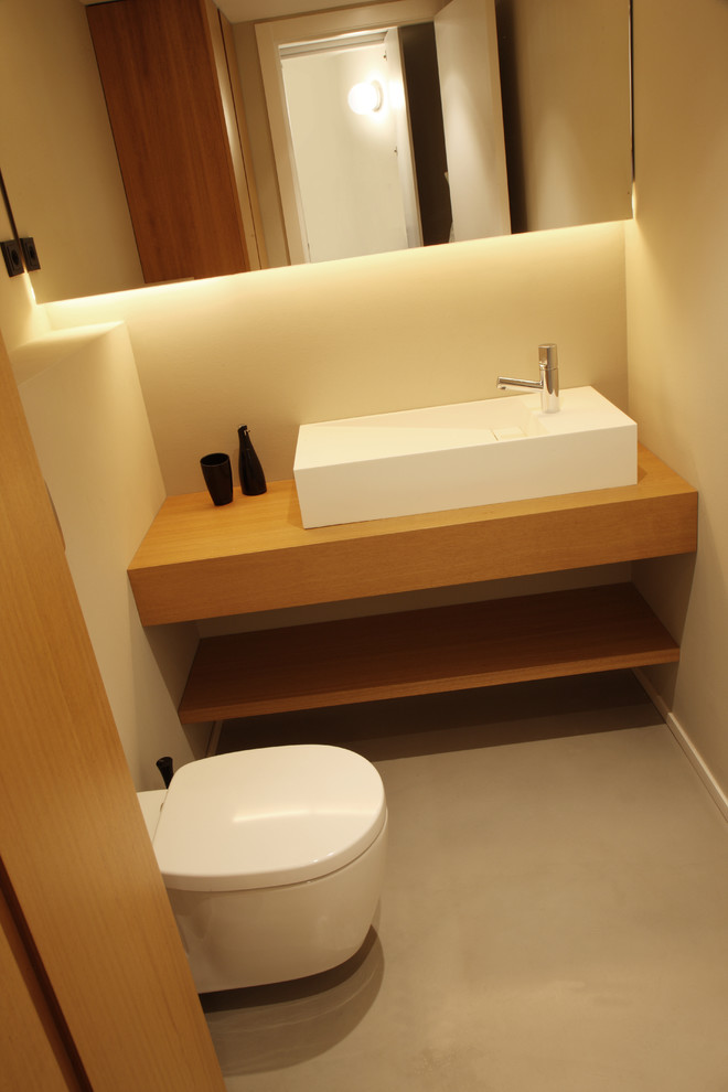 Esempio di una piccola stanza da bagno padronale con WC sospeso, top in legno, pareti beige, pavimento in legno massello medio, lavabo sospeso e pavimento marrone