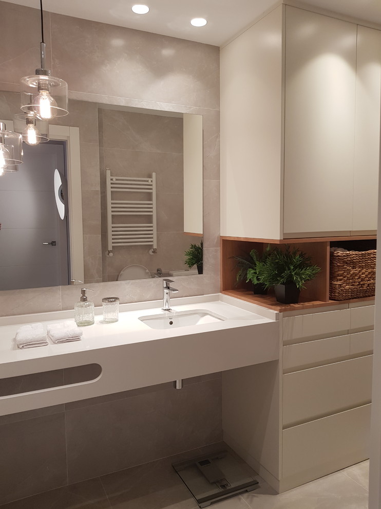 Modelo de cuarto de baño principal moderno de tamaño medio con puertas de armario blancas, baldosas y/o azulejos grises, paredes grises, lavabo suspendido, suelo gris y encimeras blancas