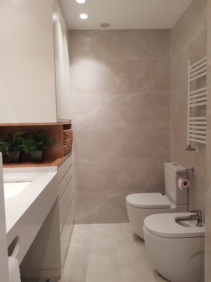 Modelo de cuarto de baño principal moderno de tamaño medio con puertas de armario blancas, baldosas y/o azulejos grises, paredes grises, lavabo suspendido, suelo gris y encimeras blancas