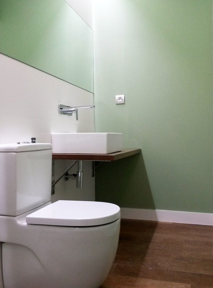 Immagine di una stanza da bagno padronale moderna di medie dimensioni con WC a due pezzi, piastrelle bianche, piastrelle in ceramica, pareti bianche, pavimento in gres porcellanato, lavabo a bacinella, top in legno e pavimento marrone
