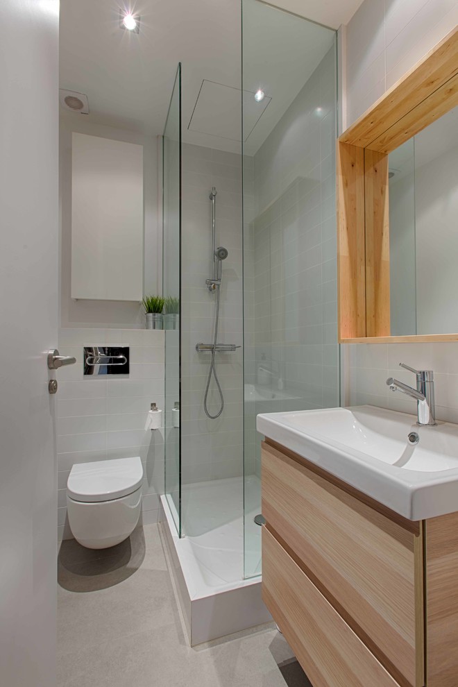 Idee per una piccola stanza da bagno con doccia nordica con ante lisce, ante in legno chiaro, doccia ad angolo, WC sospeso, pareti bianche e lavabo integrato