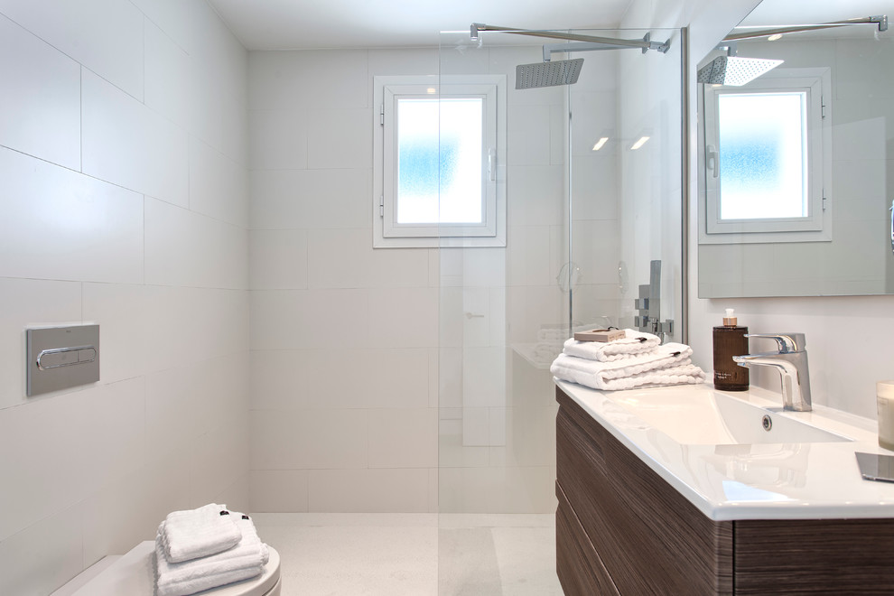 Foto di una piccola stanza da bagno con doccia nordica con consolle stile comò, ante in legno scuro, doccia a filo pavimento e lavabo integrato