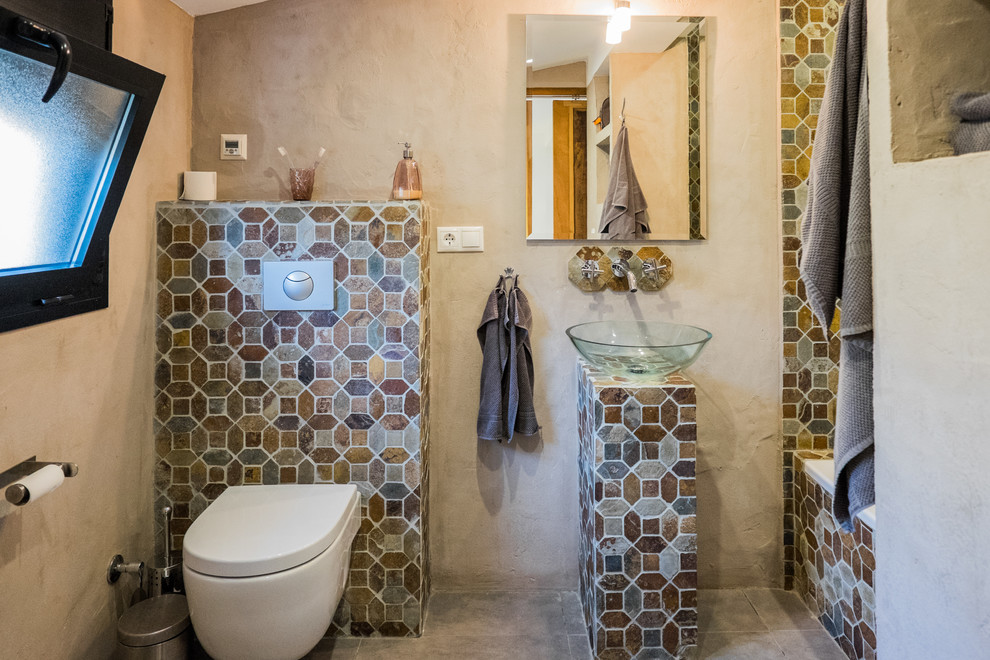 Идея дизайна: маленькая главная ванная комната в средиземноморском стиле с настольной раковиной, столешницей из плитки, накладной ванной, душем над ванной, унитазом-моноблоком, коричневой плиткой, каменной плиткой, бежевыми стенами и бетонным полом для на участке и в саду