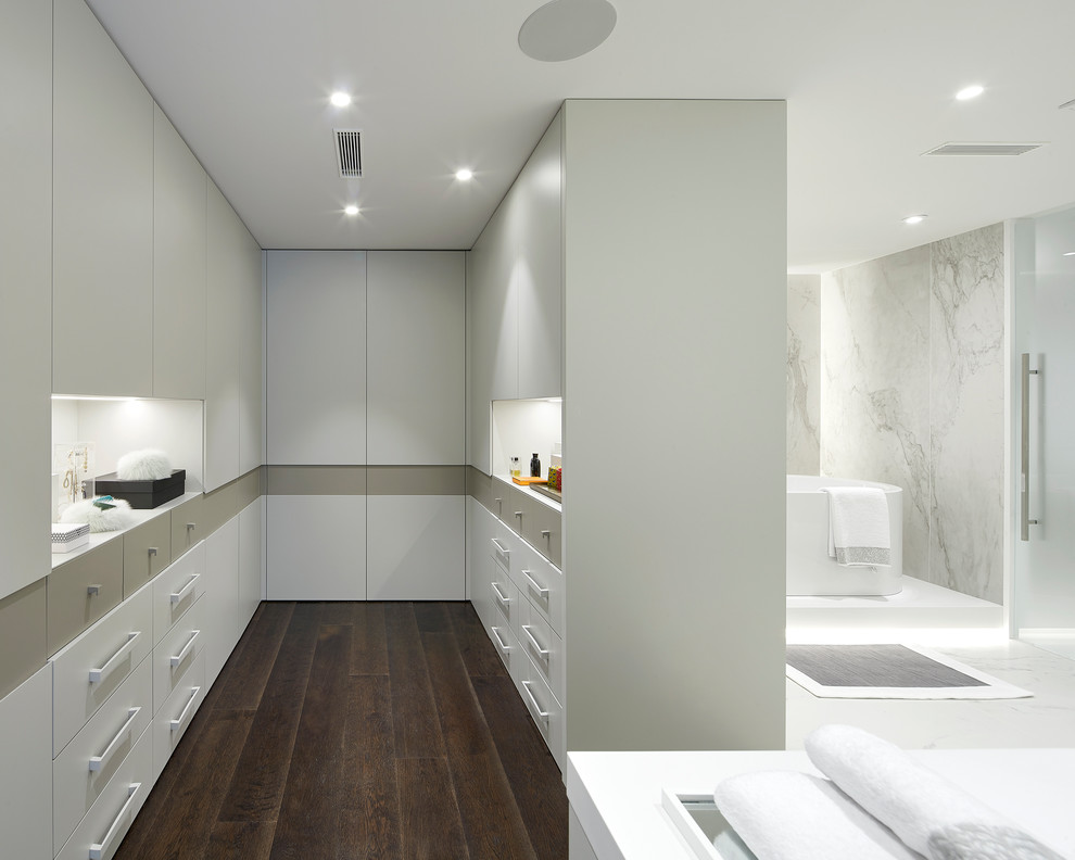 Стильный дизайн: серо-белая ванная комната в современном стиле с плоскими фасадами, белыми фасадами, отдельно стоящей ванной, мраморной плиткой и белой столешницей - последний тренд