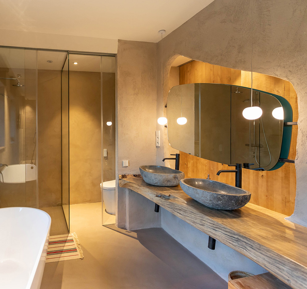 Idées déco pour une salle d'eau méditerranéenne avec un espace douche bain, un mur beige, une vasque, un plan de toilette en bois, un sol beige, une cabine de douche à porte coulissante et un plan de toilette beige.