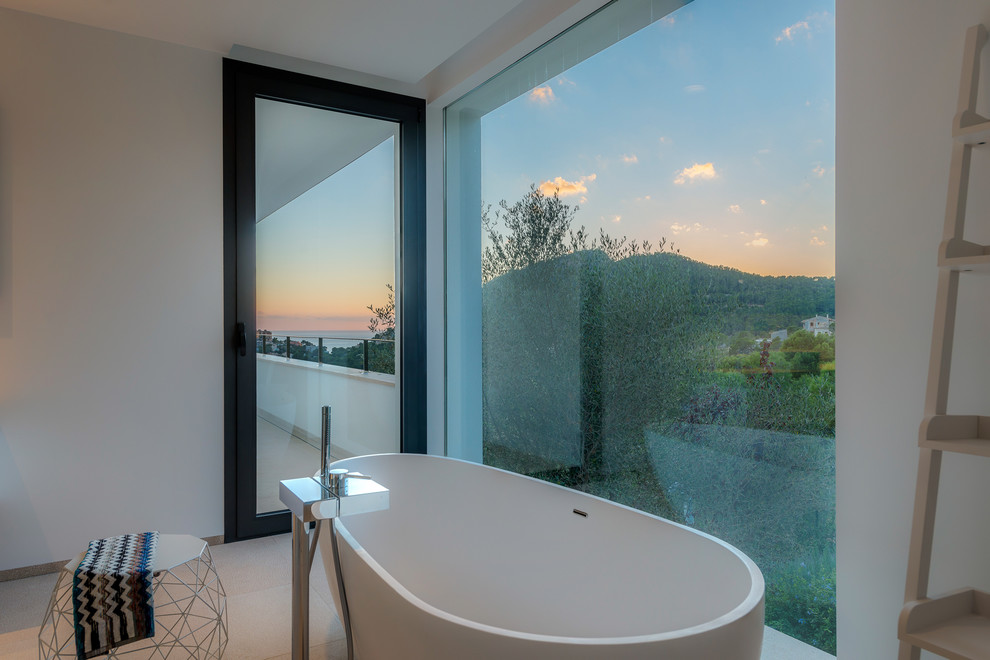 Foto di una stanza da bagno design di medie dimensioni con vasca freestanding e pareti bianche