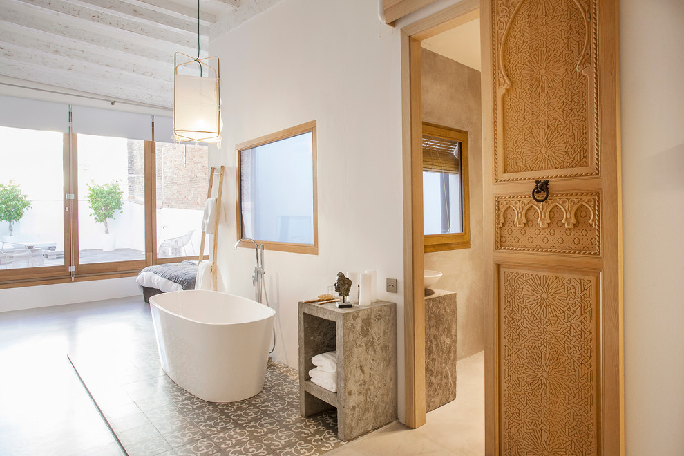 Cette image montre une salle d'eau méditerranéenne de taille moyenne avec une baignoire indépendante, un combiné douche/baignoire, un mur blanc et un sol en carrelage de céramique.