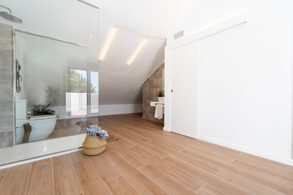 Small mediterranean bathroom in Malaga with flat-panel cabinets, white cabinets, an alcove bath, a walk-in shower, a wall mounted toilet, white tiles, ceramic tiles, white walls, porcelain flooring, a submerged sink, laminate worktops, brown floors, an open shower and white worktops.