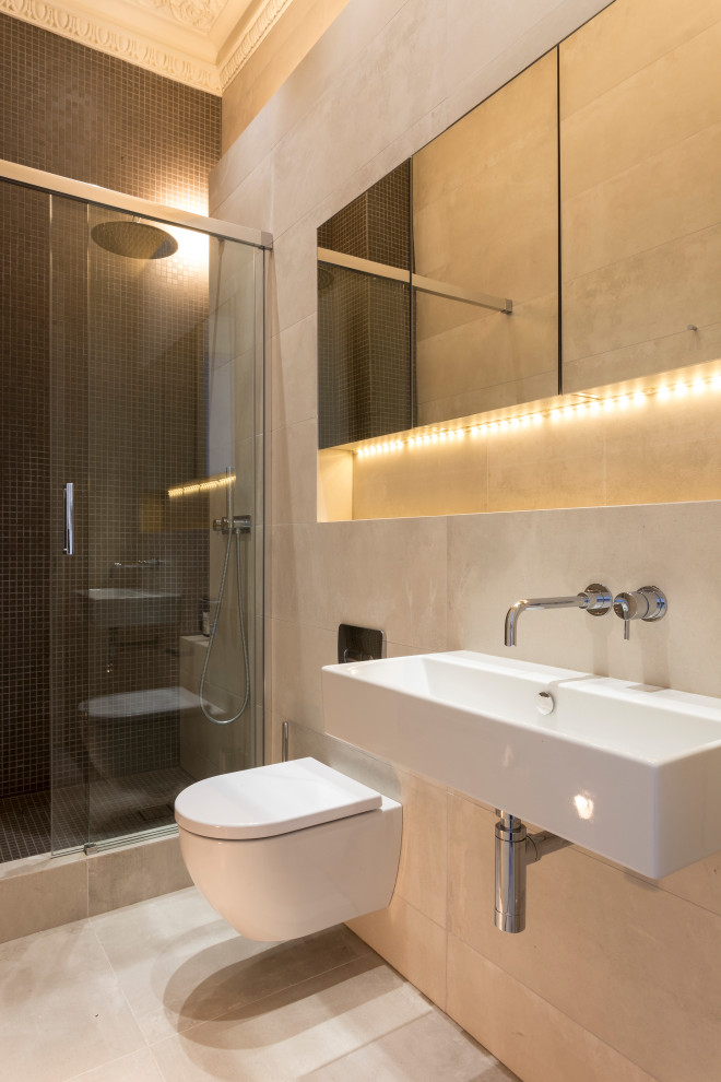 Photo of a large contemporary shower room bathroom in London with white cabinets, beige tiles, an alcove shower, a wall mounted toilet, porcelain tiles, porcelain flooring, a wall-mounted sink, beige floors, a hinged door and a single sink.