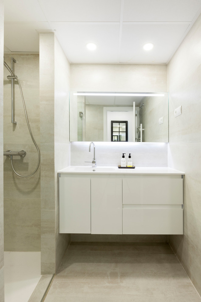 На фото: ванная комната в современном стиле с белыми фасадами, бежевой плиткой, открытым душем, белой столешницей, плоскими фасадами, бежевыми стенами, душевой кабиной, монолитной раковиной и бежевым полом с